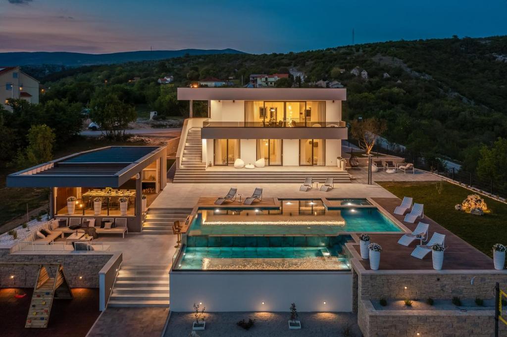una vista aerea di una casa con piscina di Luxury Villa Arya with 77sqm heated pool, hot-tub, sauna, gym, billiard, playgrounds, 6 bedroom a Bajagić