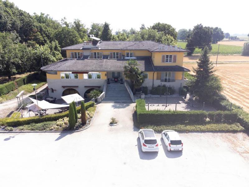 a house with two cars parked in a parking lot at La Quercia Hotel con Ristorante in San Giovanni in Croce