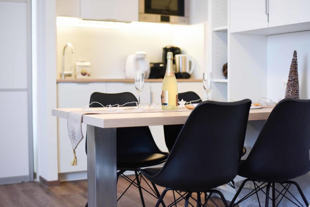 una cocina con mesa con sillas y una botella de vino en Schönbrunn Design, en Viena