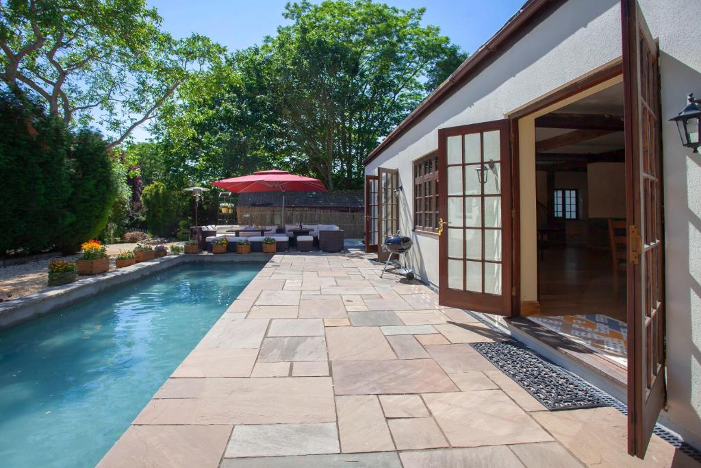 una piscina accanto a una casa di La Villa Olli -Natural pool & Hot tub a Bristol