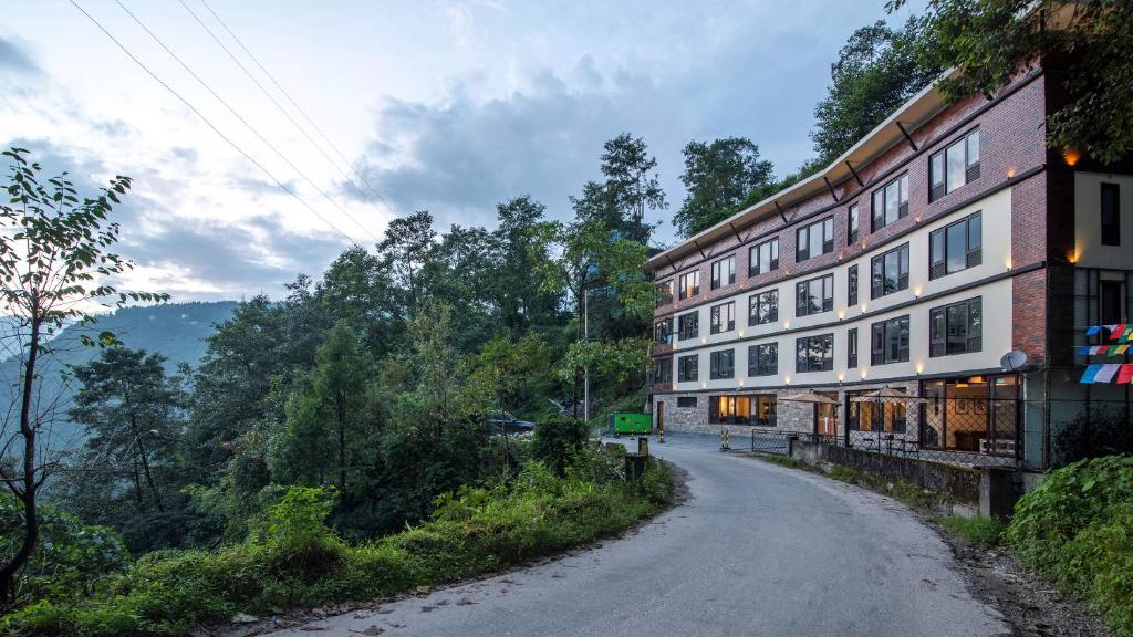 a dirt road next to a building on a hill at Indra Mandala,Gangtok - AM Hotel Kollection in Gangtok