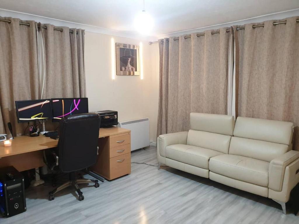 a living room with a couch and a desk and a computer at Your Home away from home in Leeds - on the Ring Rd in Leeds