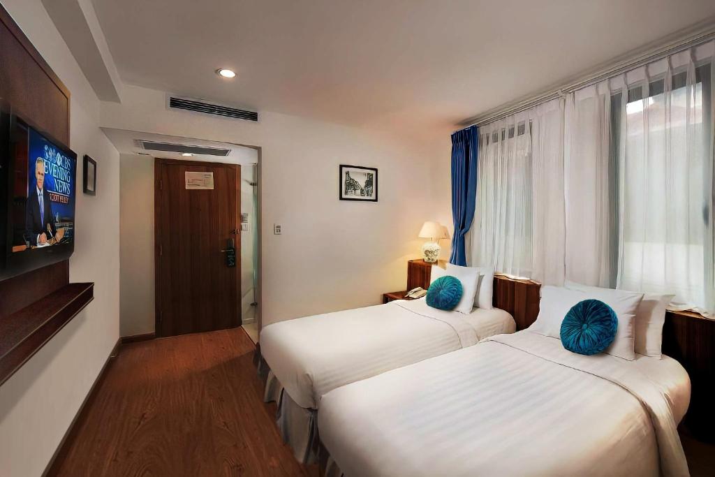Postel nebo postele na pokoji v ubytování Aviary Hanoi Hotel & Travel