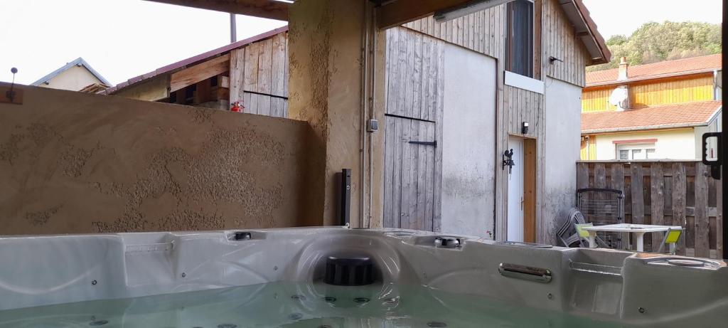 a bath tub in a room with a building at Gîte de charme avec jacuzzi étang babyfoot et rivière 
