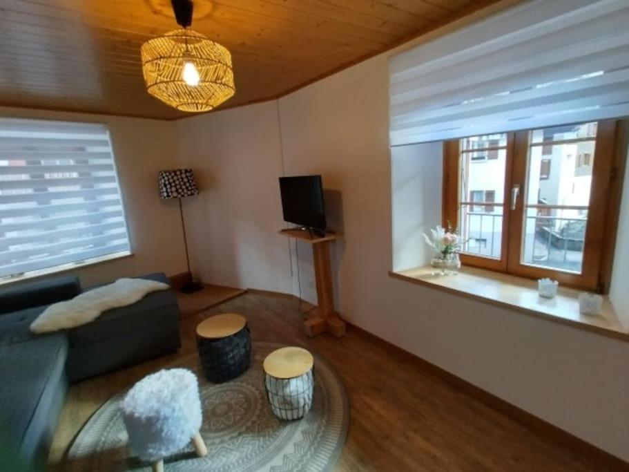 ein Wohnzimmer mit Sofa und Fernseher in der Unterkunft Centre Ville Appartement in Leukerbad