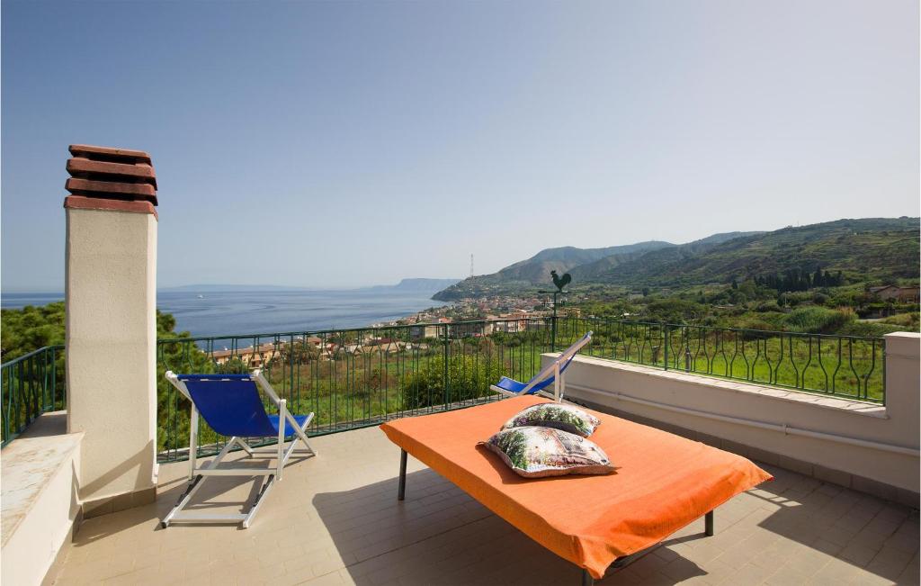 een tafel en stoelen op een balkon met uitzicht bij Cozy Home In Villa San Giovanni With Kitchen in Villa San Giovanni
