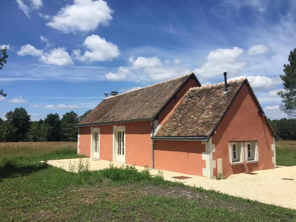 una pequeña casa roja en medio de un campo en Domaine de la Trigalière, en Ambillou