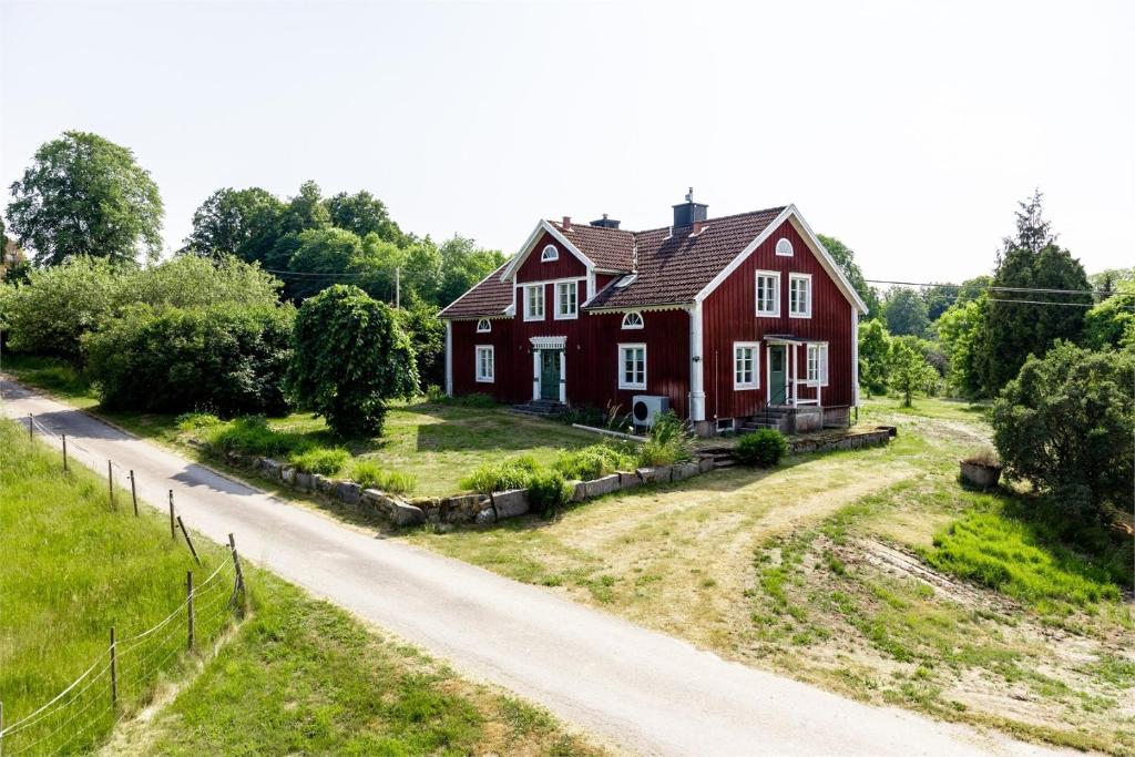 une maison rouge sur le côté d'une route dans l'établissement Kurrebo Vandrarhem, à Urshult