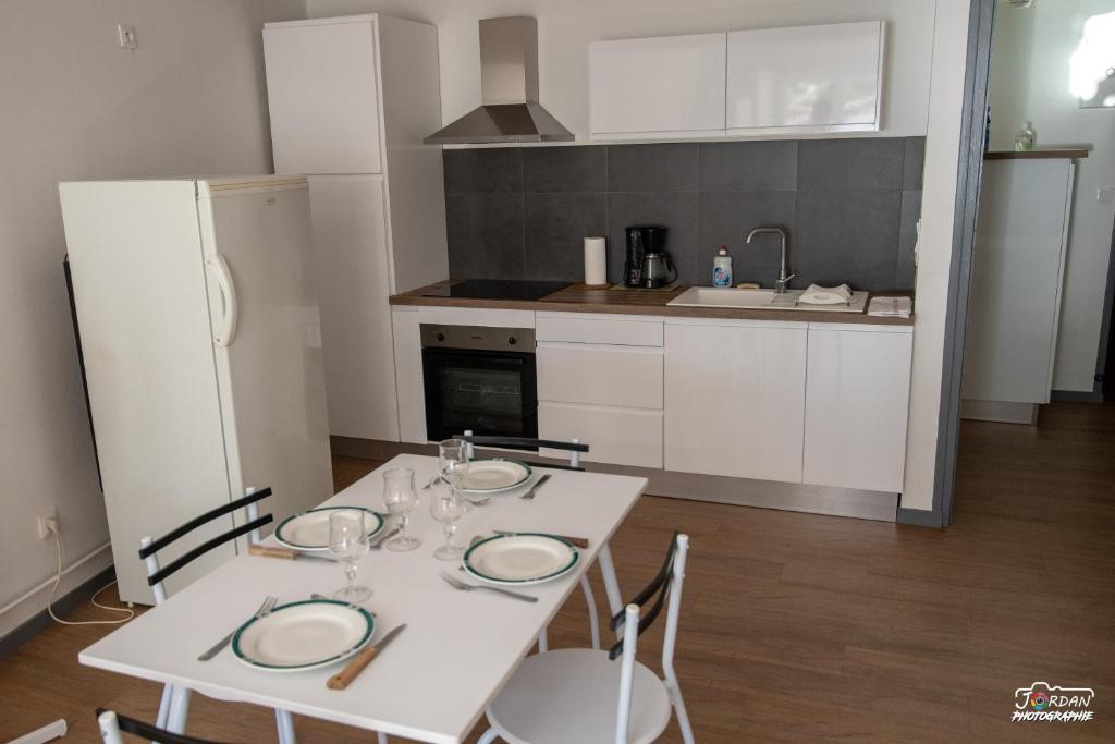 eine Küche mit einem weißen Tisch und einem weißen Kühlschrank in der Unterkunft Hyper centre - wifi - cosy - Gare in Bourg-en-Bresse