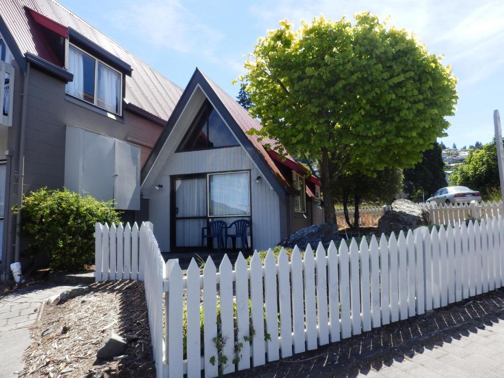 una cerca blanca frente a una casa en Wakatipu View Apartments en Queenstown