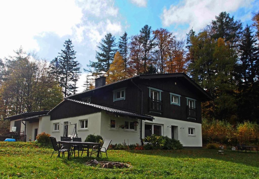 a black and white house with a table and chairs at Orańska in Miedzygorze