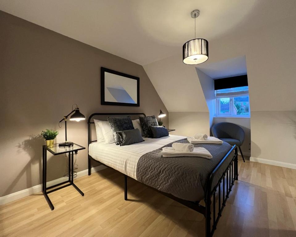 um quarto com uma cama, uma mesa e um candeeiro em Spacious Townhouse with Parking em Telford