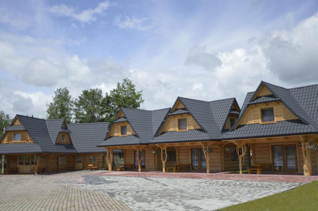 une grande maison en bois avec un toit noir dans l'établissement Domki i pokoje Toporówka, à Zakopane