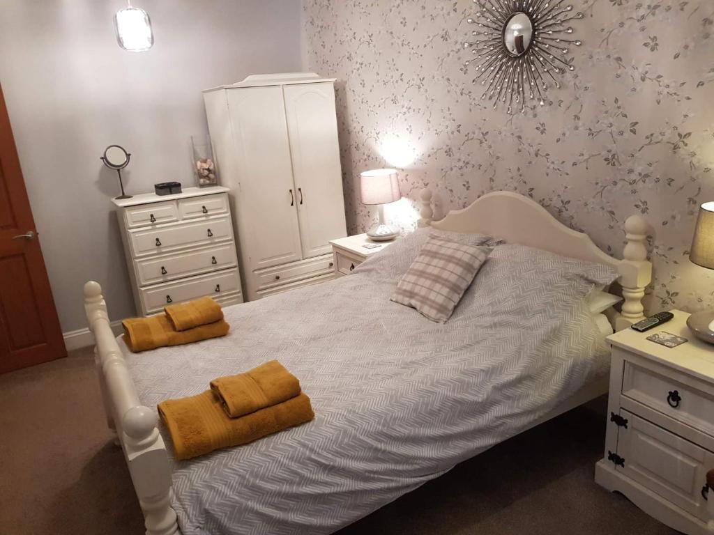 ein Schlafzimmer mit einem weißen Bett mit zwei braunen Kissen in der Unterkunft Bancroft Apartment in Durham