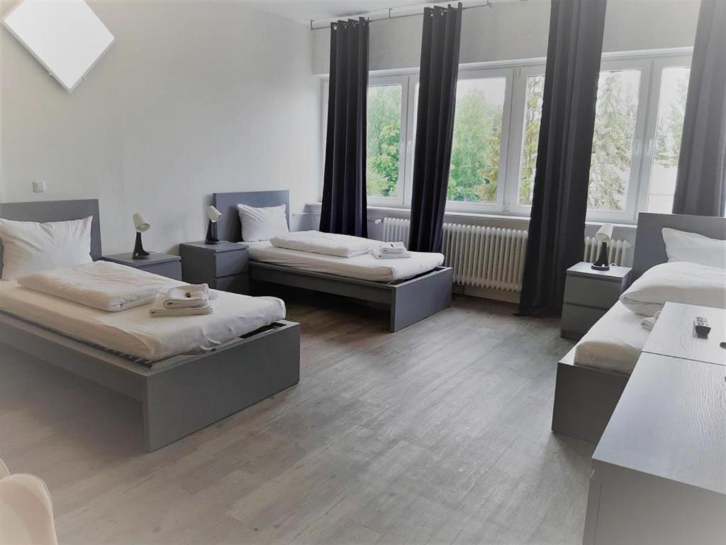 a bedroom with two beds and two windows at Mehrbett-Apartment 8 Citynah, einfache Ausstattung in Hamburg