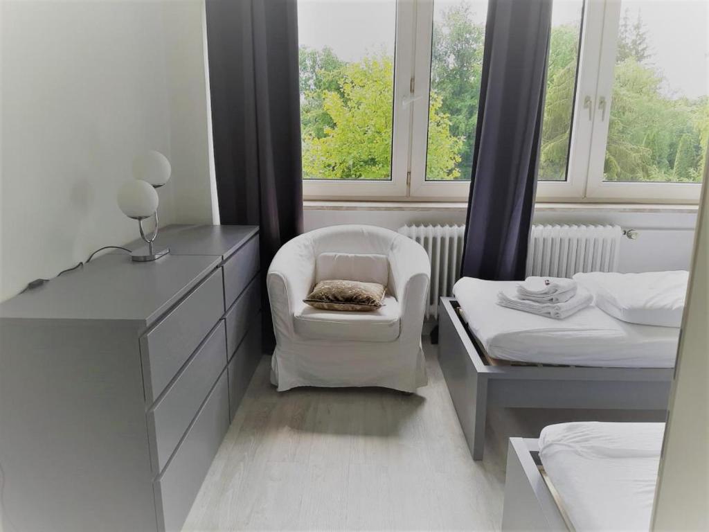 a bedroom with a chair and a bed and a window at Mehrbett-Apartment 4 Citynah, einfache Ausstattung in Hamburg