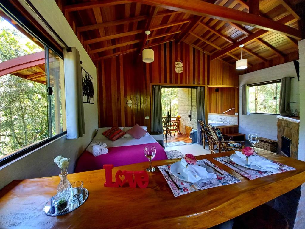 sala de estar con mesa de madera y cama en Chalé Riacho Frio, en Gonçalves