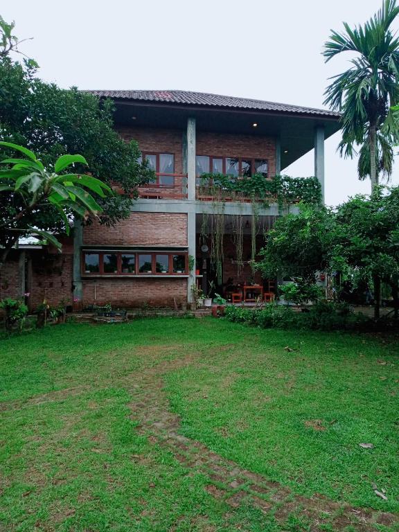 a house with a green yard in front of it at Bua Guest House in Medan