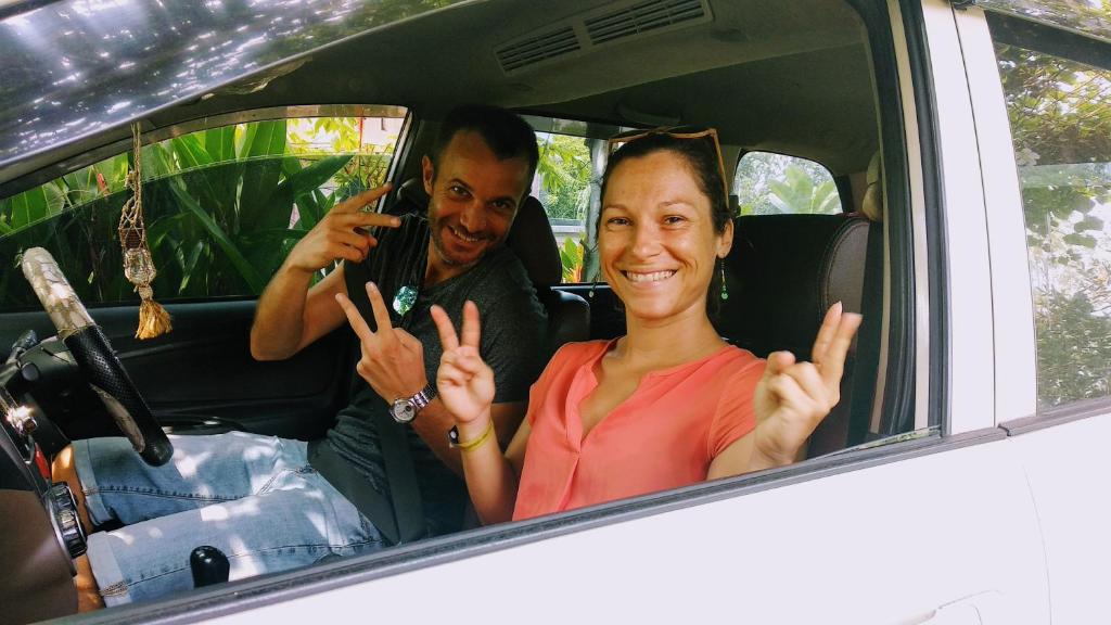 a man and a woman sitting in a car at Bua Guest House in Medan