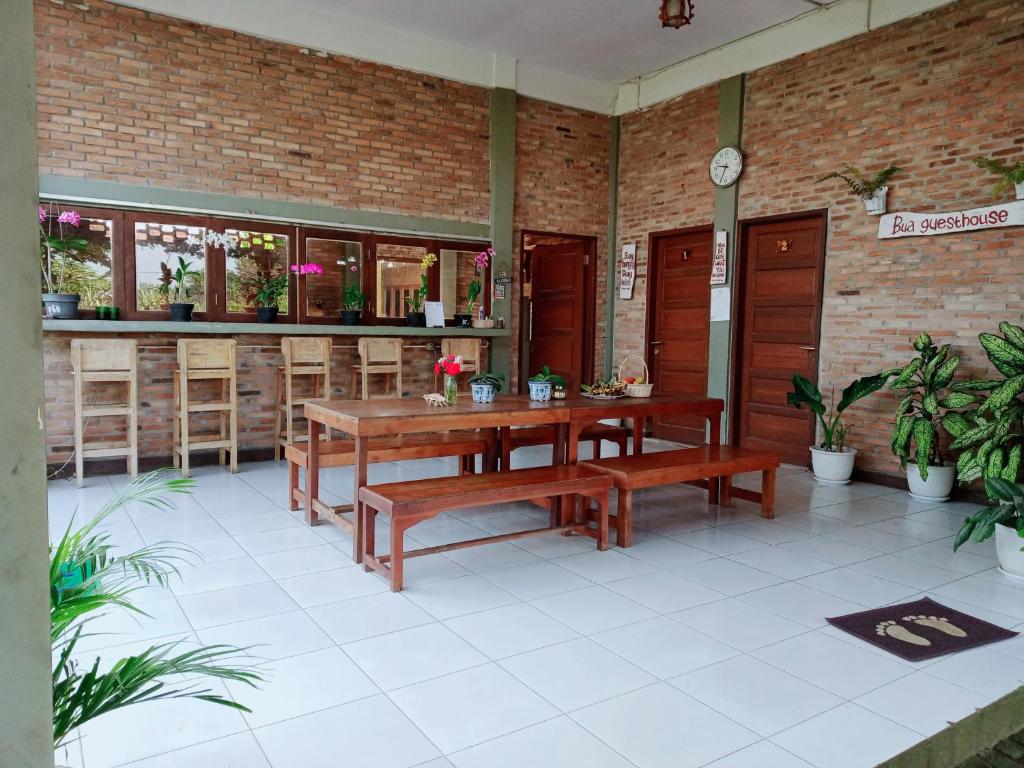 a patio with benches and a table and a bar at Bua Guest House in Medan