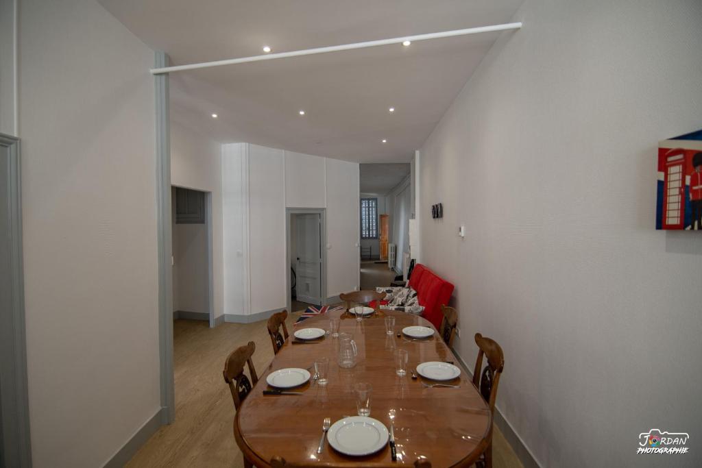 a dining room with a long wooden table and chairs at Hyper centre - 3 chambres - Gare - wifi - cosy in Bourg-en-Bresse