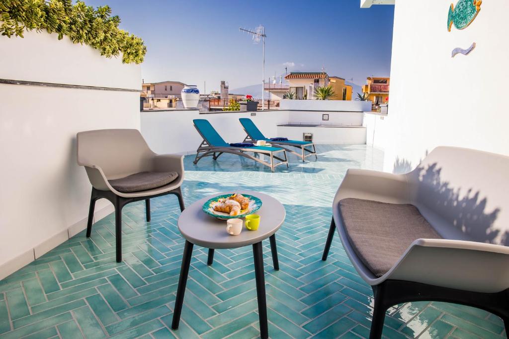 a balcony with chairs and a bowl of food on a table at Palazzo De Gregorio Apartment Napoli in SantʼAntonio Abate