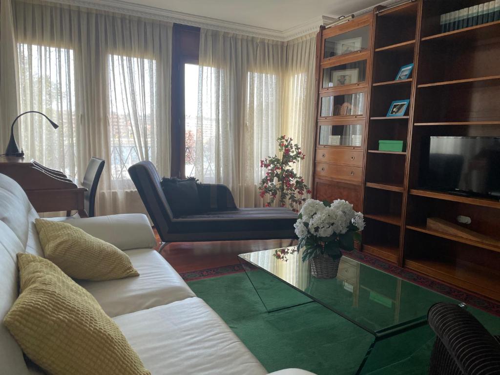 a living room with a white couch and a television at RIVER SUITE Apartment in Portugalete