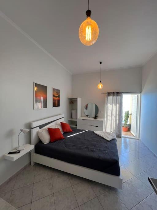 a bedroom with a large bed with black sheets and red pillows at Pôr do Sol in Funchal