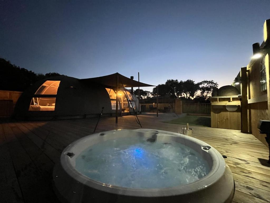 a large bath tub on a patio with a tent at Moonlight Dome Tent in Tenby