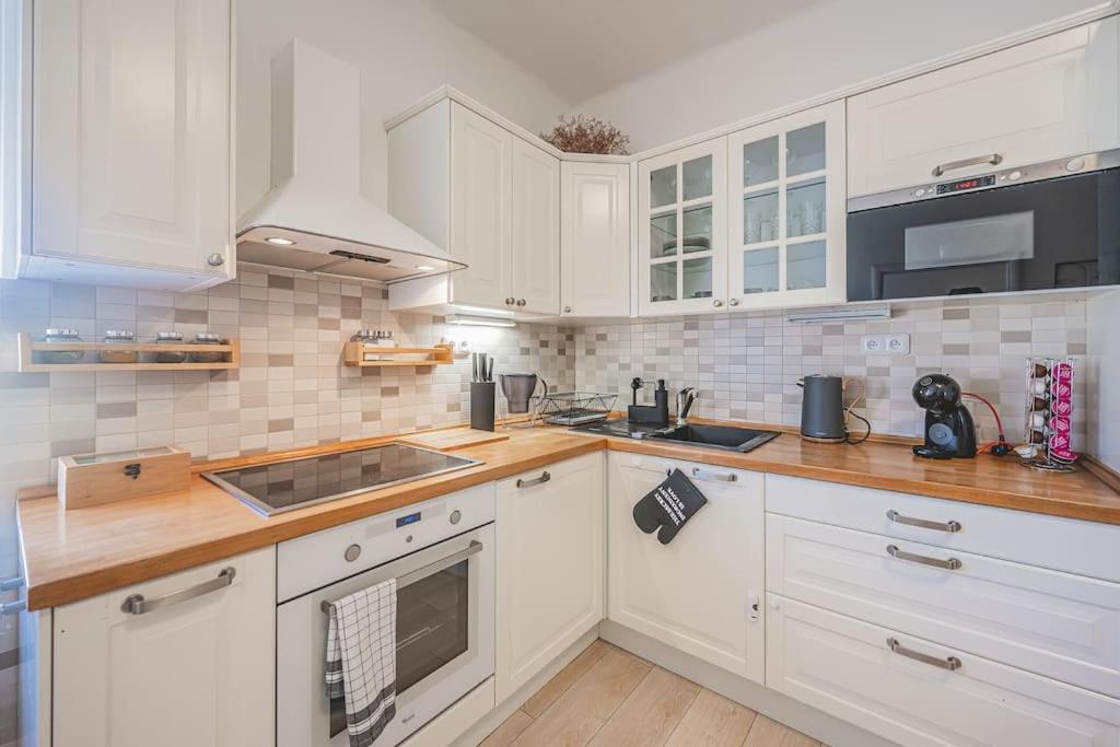 a kitchen with white cabinets and wooden counter tops at Carolina's Great Choice For Your Stay At Hradec Kralove in Hradec Králové