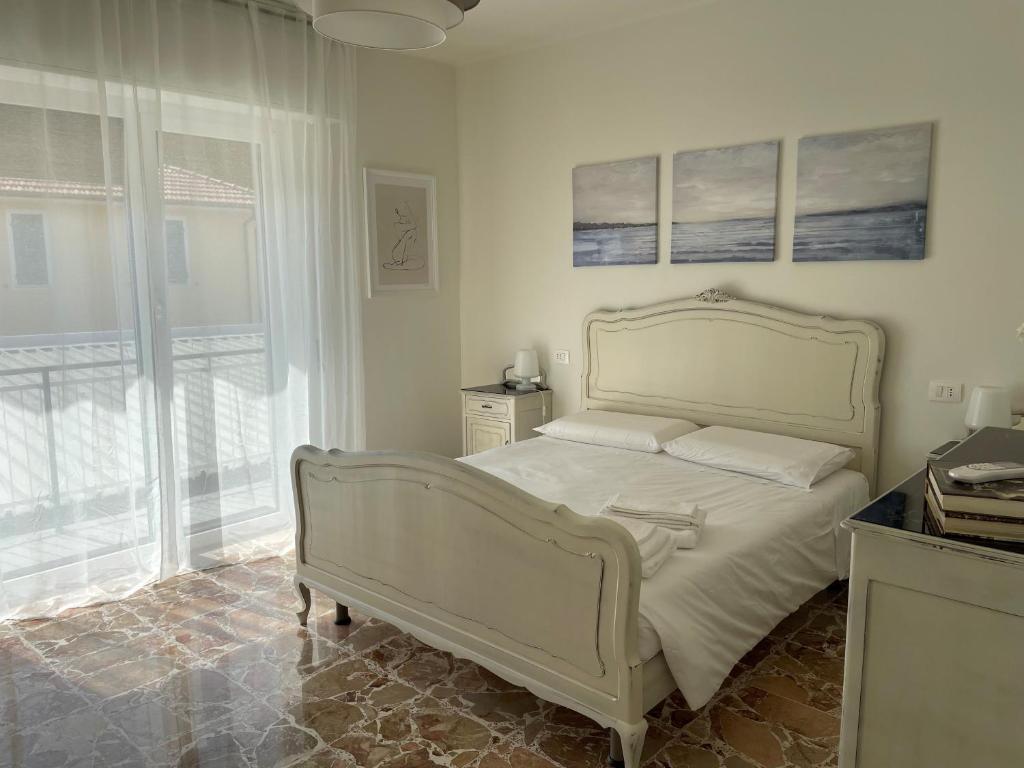 een slaapkamer met een wit bed en een raam bij Casa Gelindo - large and fine apartment with two bathrooms in Sestri Levante
