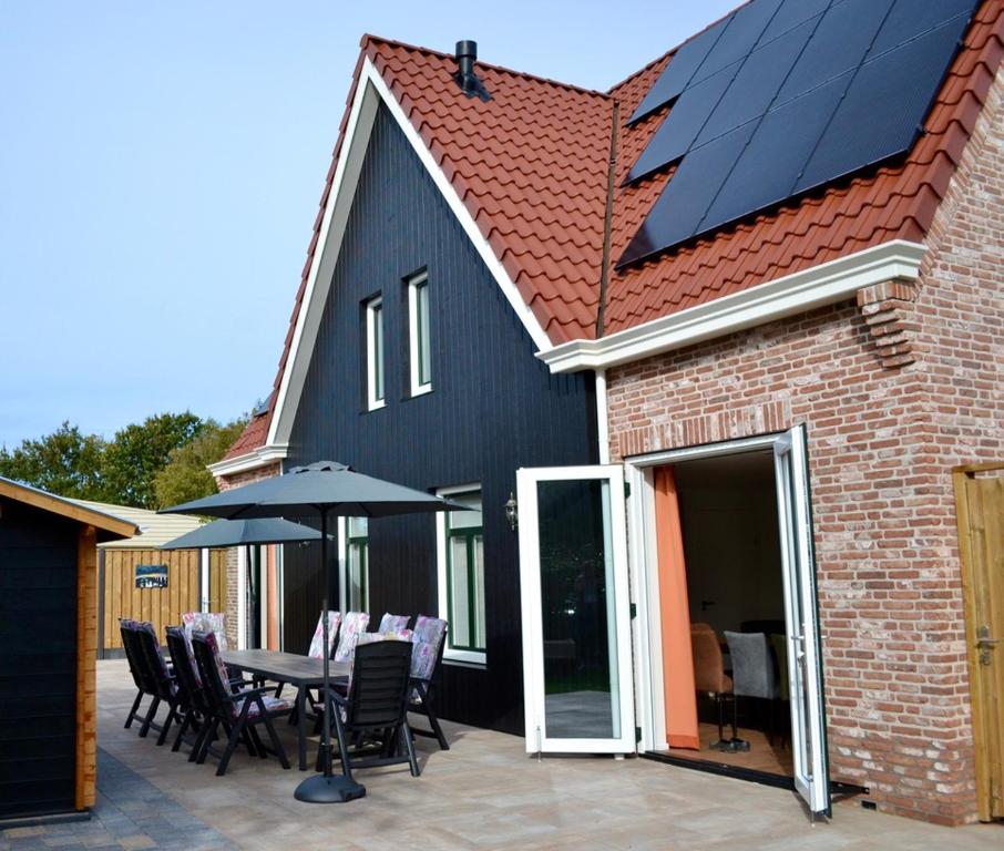 een huis met een zonnedak met een tafel en stoelen bij Luxe vakantievilla Zoutelande in Zoutelande