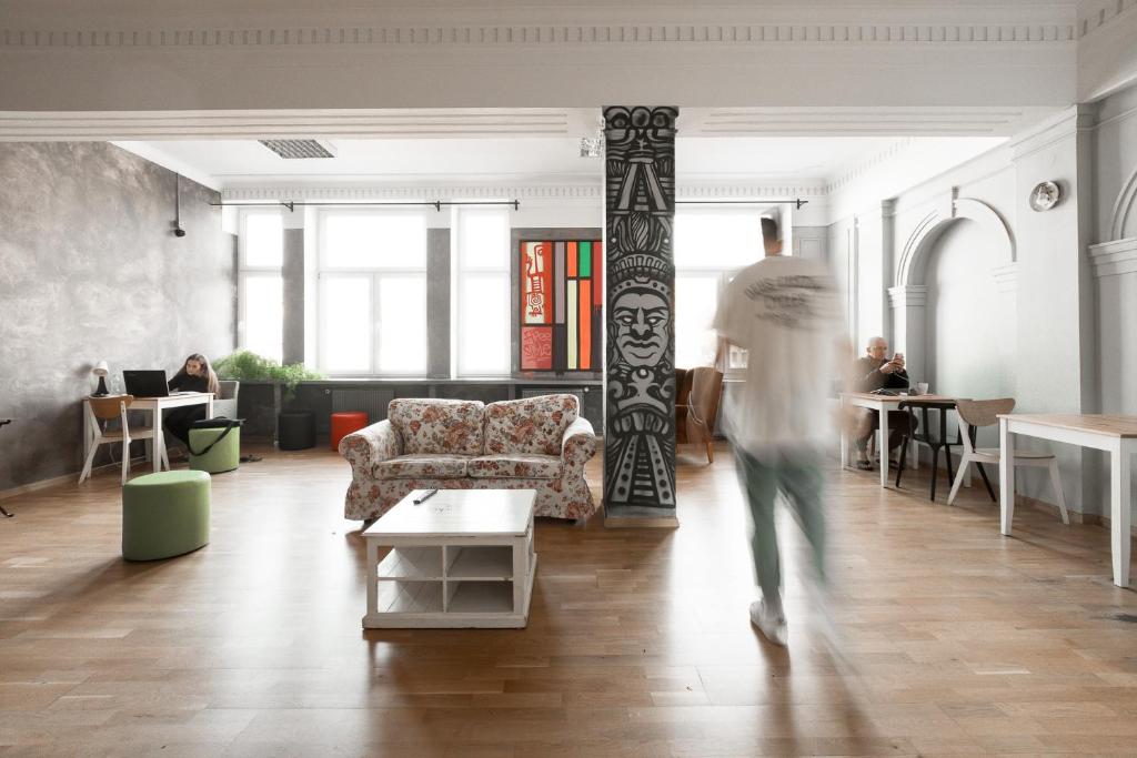 a man walking through a living room with a couch at Casa De Wawa in Warsaw