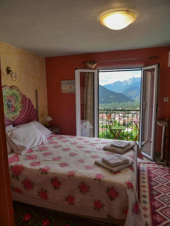 a bedroom with a bed and a large window at Η Φωλιτσα in Karpenisi