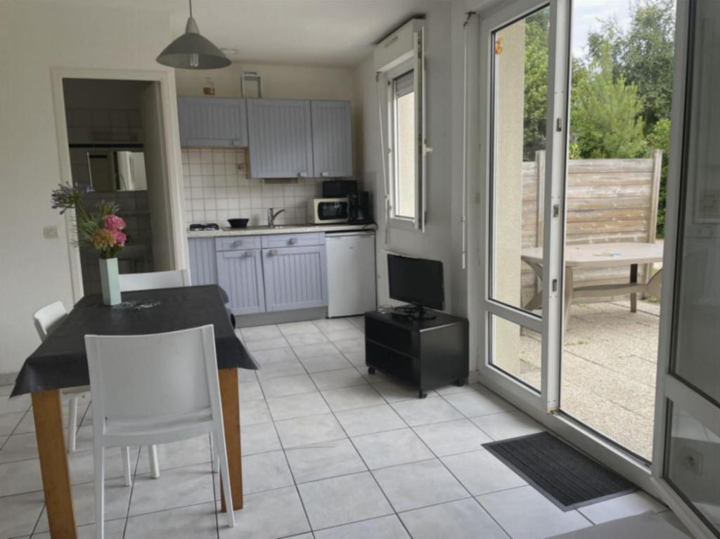 a kitchen with a table and a television in it at Le Braz Saint Lunaire in Saint-Lunaire