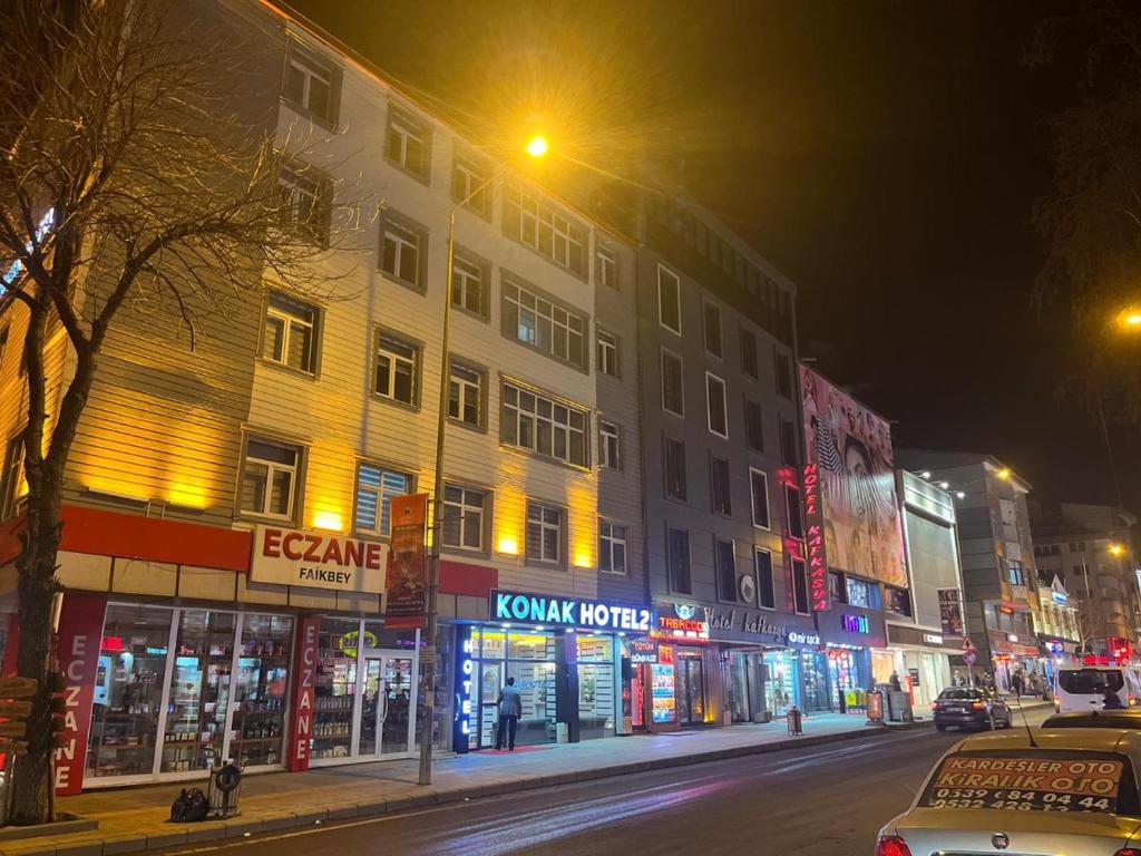 uma rua da cidade à noite com um edifício e lojas em KONAK HOTEL 2 em Kars