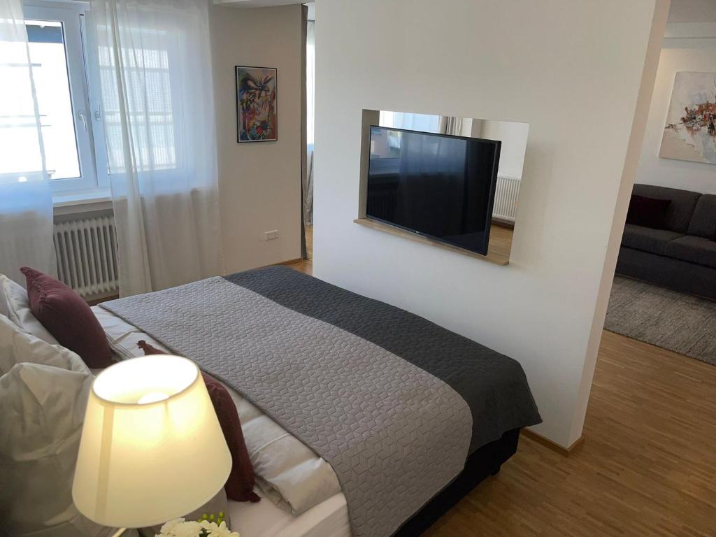 ein Schlafzimmer mit einem Bett und einem TV an der Wand in der Unterkunft Wilhelmsapartment in Friedrichshafen