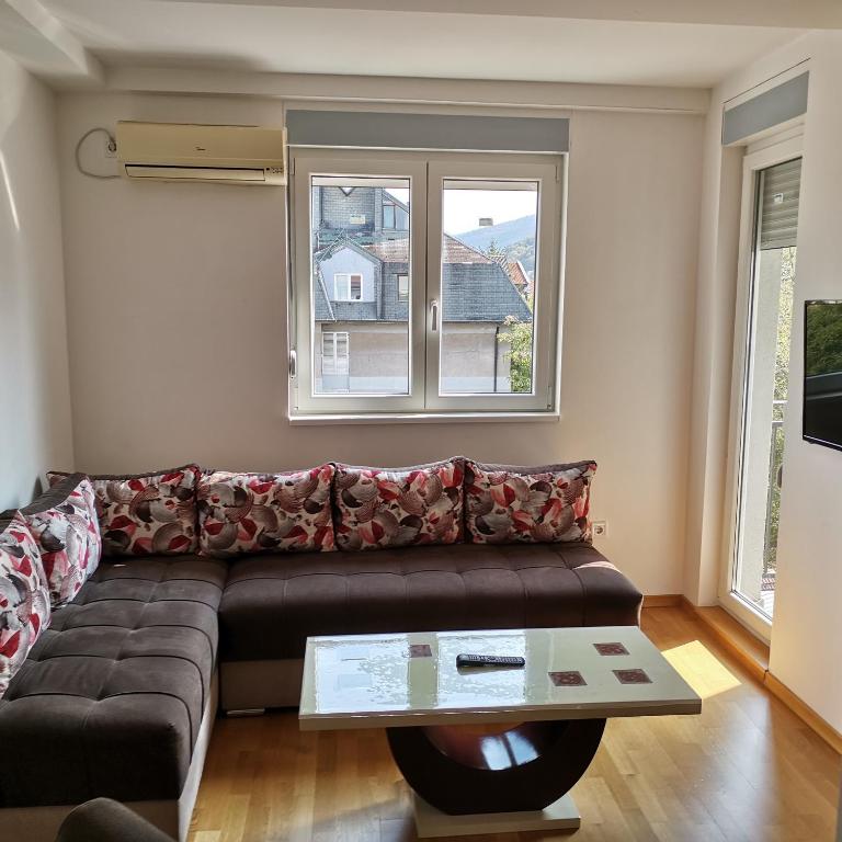 a living room with a couch and a table at Apartman Lea & parking u garaži in Soko Banja