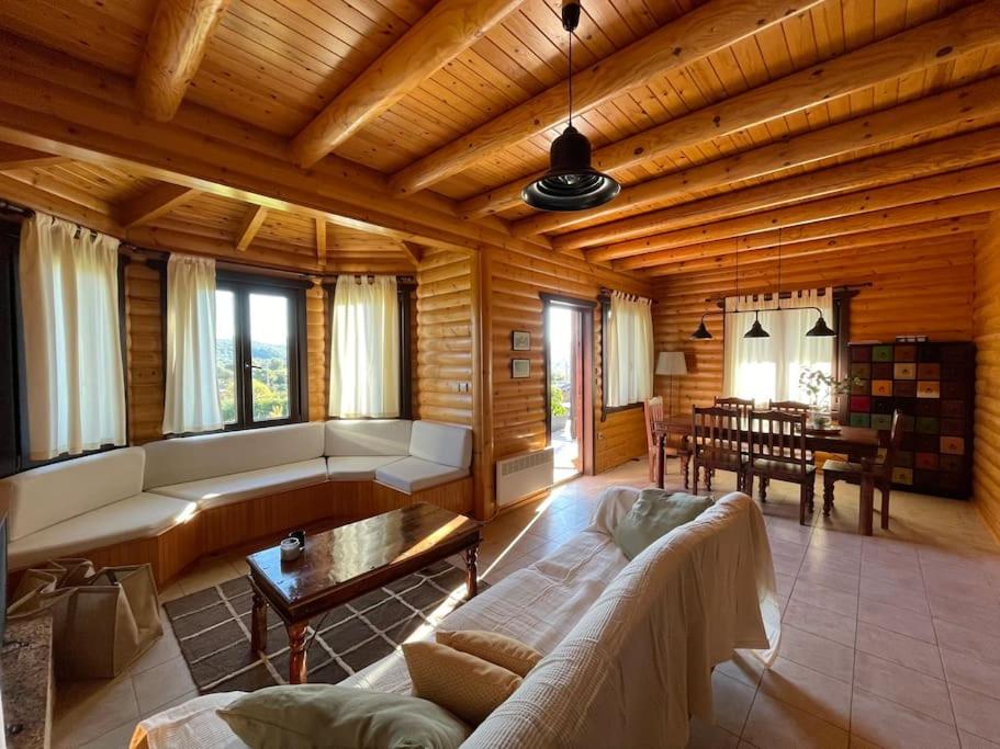 uma sala de estar com um sofá e uma mesa em Chalet Klimatia - Όμορφη ξύλινη μεζονέτα με τζάκι 