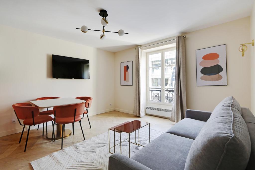 un salon avec un canapé et une table dans l'établissement Pick A Flat's Apartments in Saint-Lazare - Rue de Londres, à Paris