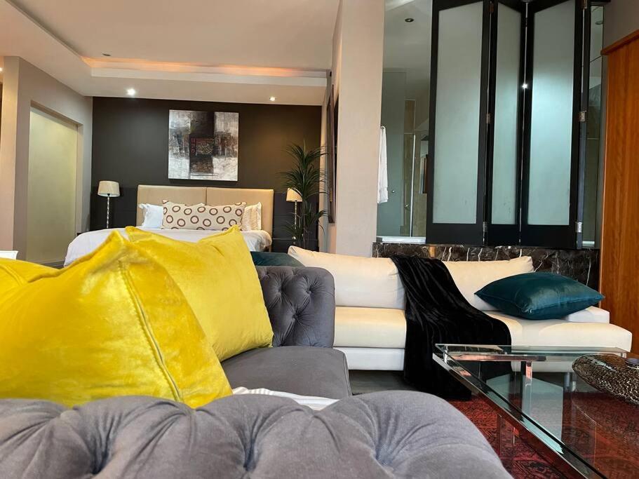 ein Wohnzimmer mit einem Sofa und einem Bett in der Unterkunft Apartment on 8th in Johannesburg