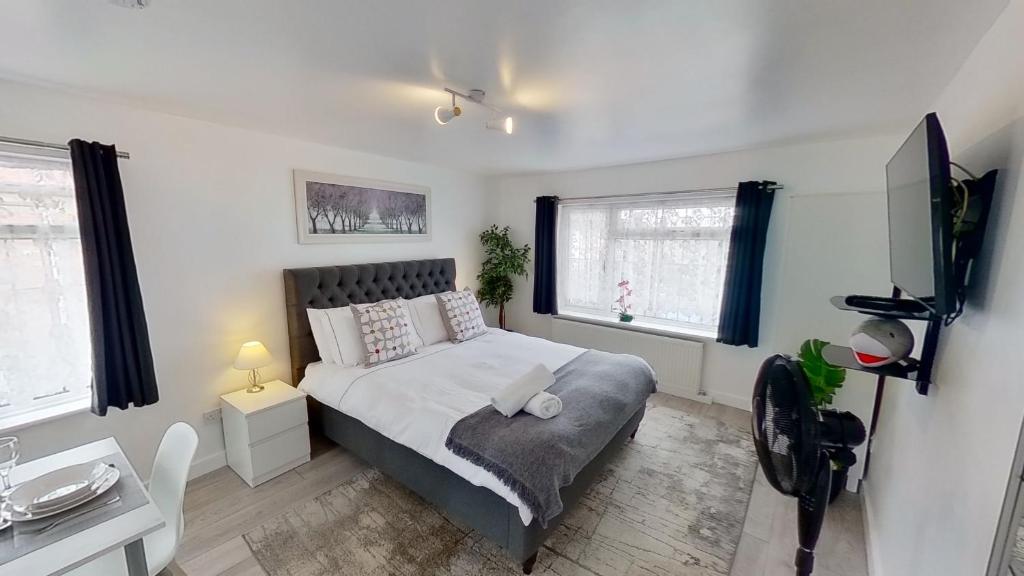 a bedroom with a bed and two windows at Symons House in Chatham