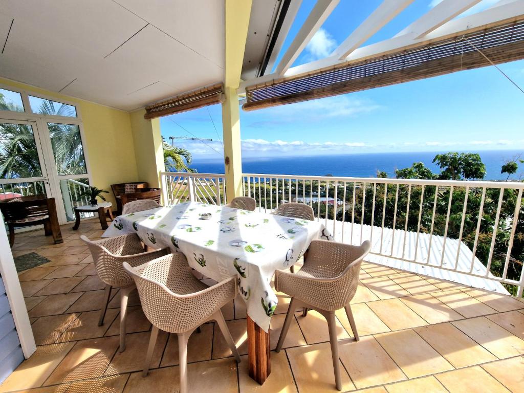 ein Esszimmer mit einem Tisch und Stühlen auf dem Balkon in der Unterkunft Villa ARC-EN-CIEL in Petite Île