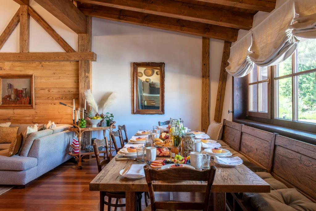 a dining room with a long table with food on it at Kikombe Lodge in Sankt Anton am Arlberg
