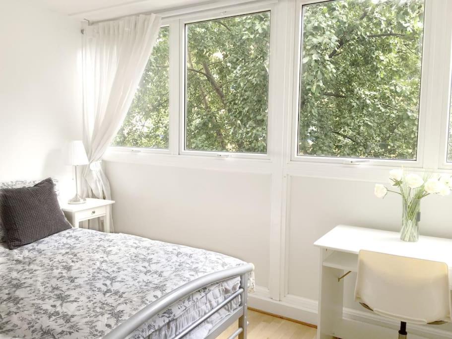 a bedroom with a bed and a desk and two windows at Fab 3-bed 3-bath Duplex Oxford Street, Regents Park, Fitzrovia W1 in London