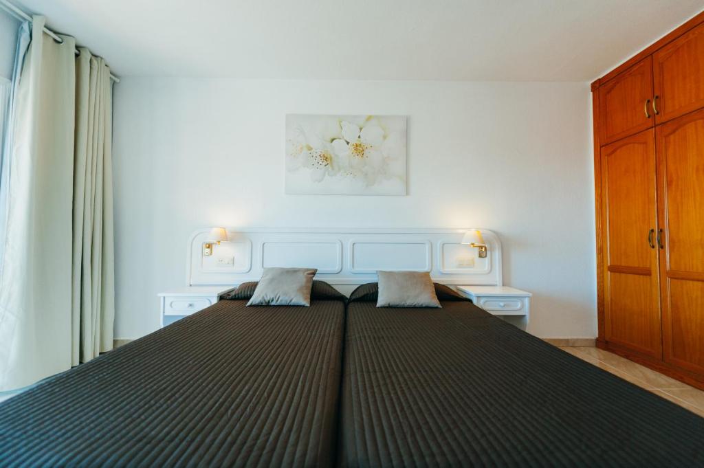 A bed or beds in a room at Aparthotel Neptuno Costadeje