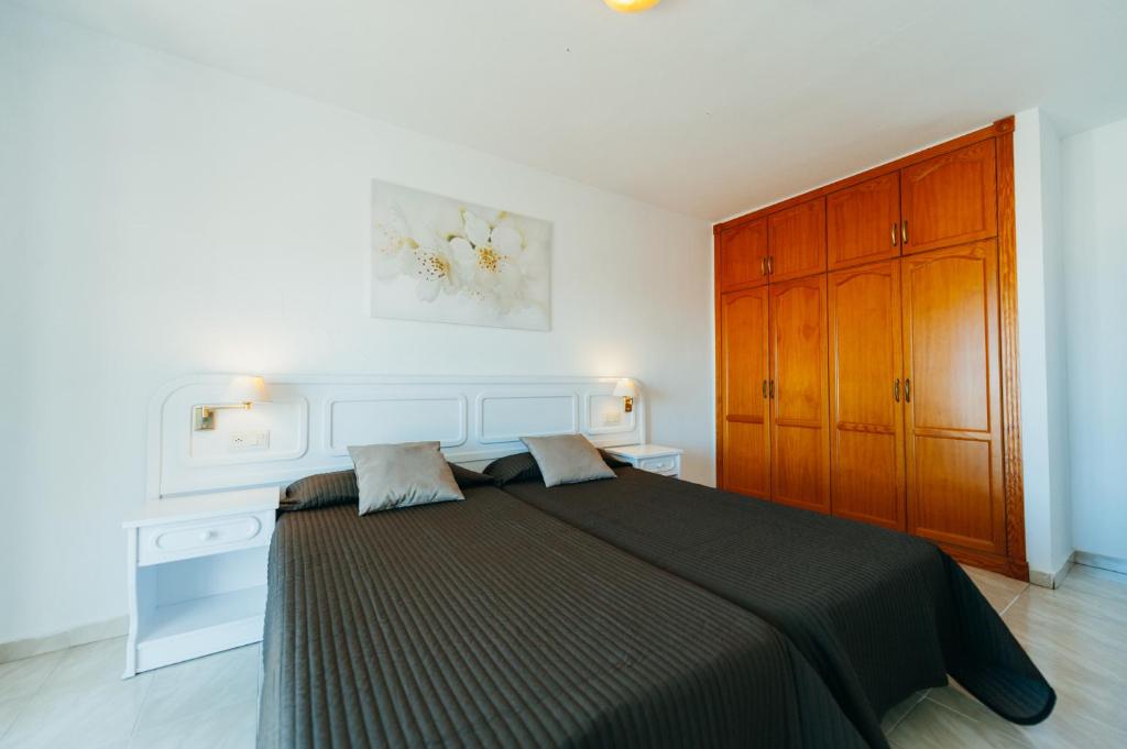 A bed or beds in a room at Aparthotel Neptuno Costadeje