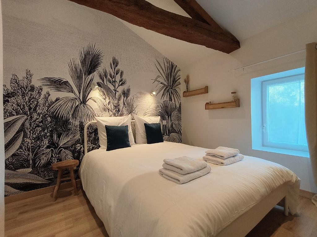 um quarto com uma cama com toalhas em Chez Emma et Louise - Maison individuelle avec stationnement em Mâcon