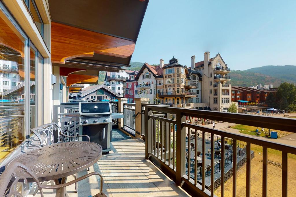 a balcony with a stove and a table and chairs at Lion Square Lodge East 310A in Vail