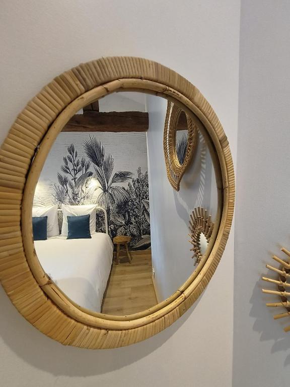 - un miroir rond avec un lit dans la chambre dans l'établissement Chez Emma et Louise - Maison individuelle avec stationnement gratuit, à Mâcon